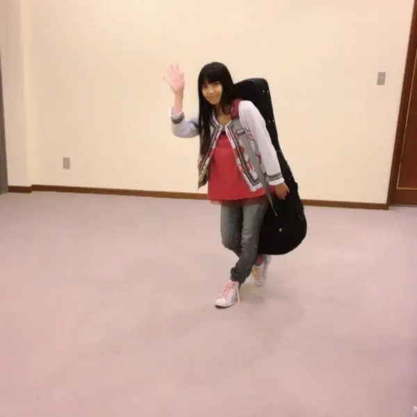矮個子的女生背起吉他　簡直就快要把身高都遮住了...